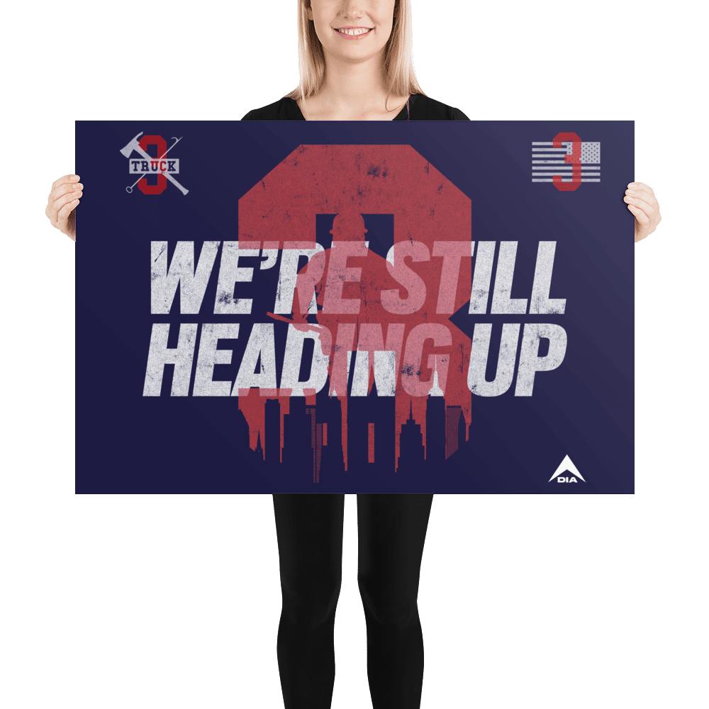 A smiling woman in black holds a navy "3 Truck" poster with white "WE'RE STILL HEADING UP" text and a red graphic.