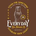 Close-up of a brown graphic featuring a standing bear, "STAND FOR SOMETHING," and "EVERYDAY DIA APPAREL CO.".